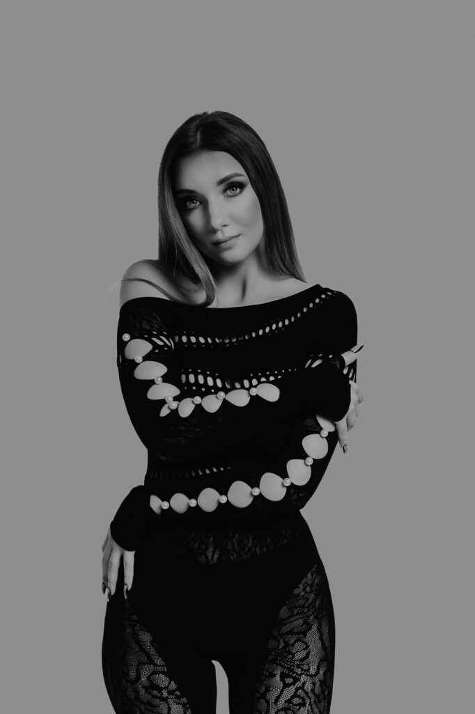 kobieta patrzy w obiektyw ubrana jest w czarny kombinezon