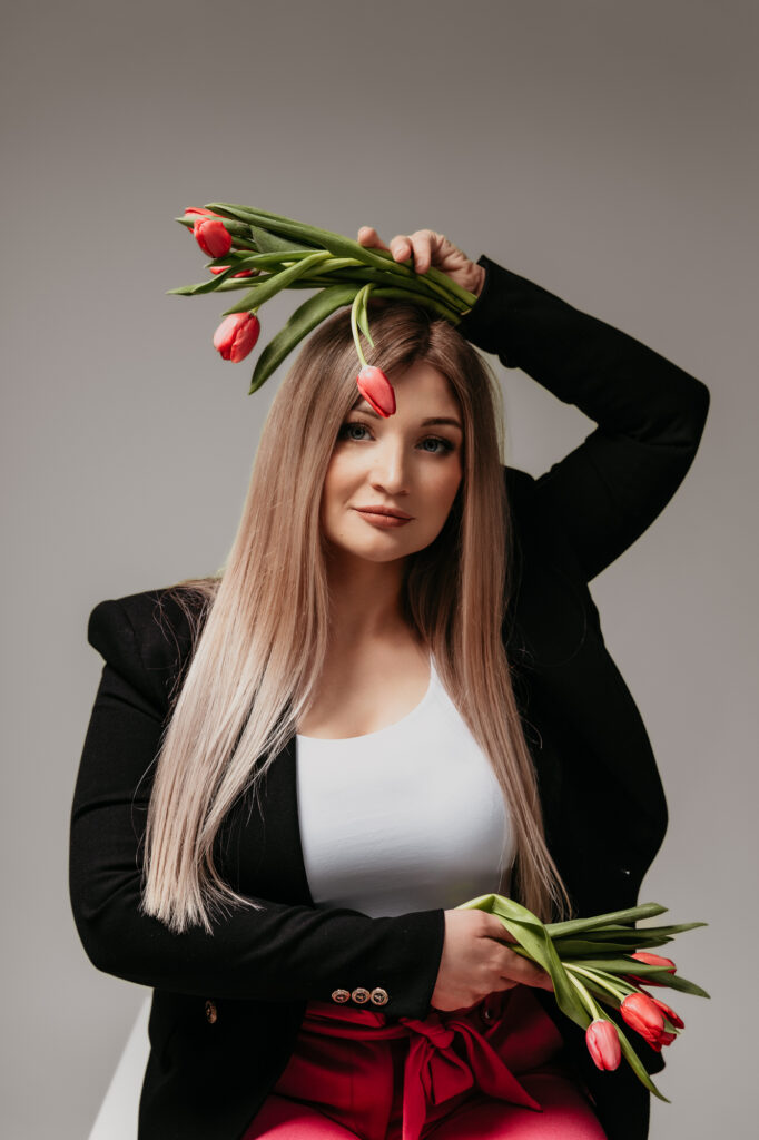 Kobieta w czarnej marynarce w rękach trzyma tulipany