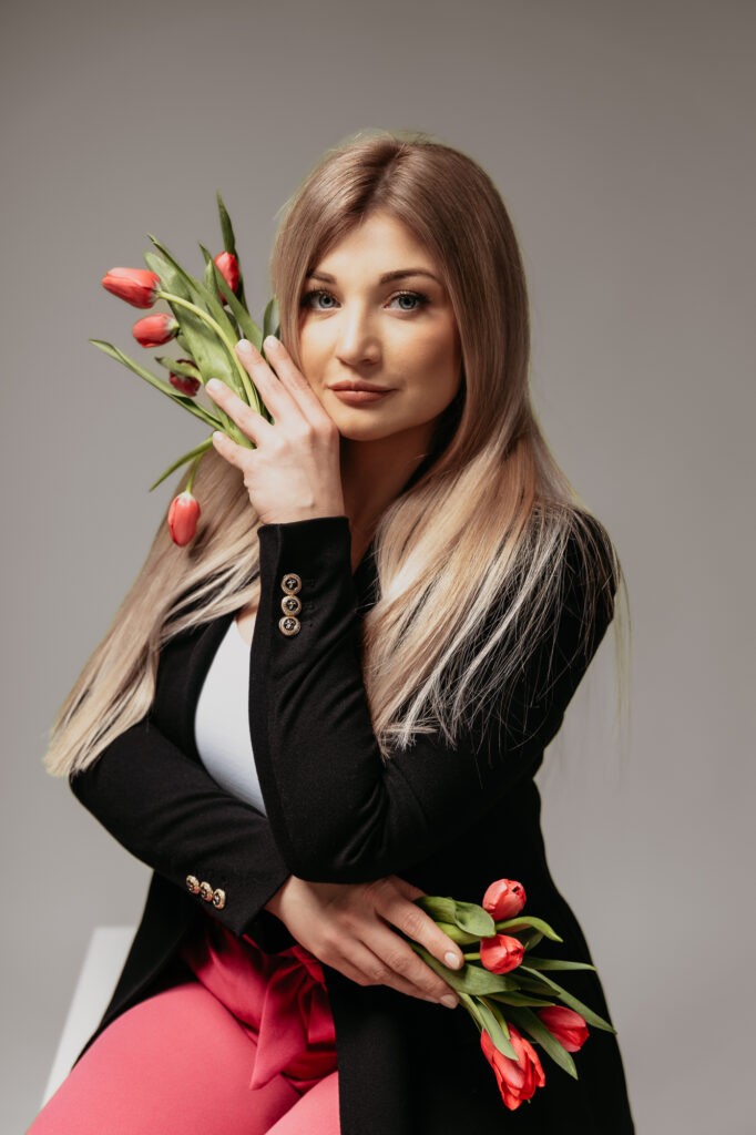 Portret eleganckiej kobiety, która trzyma w dłoniach kwiaty