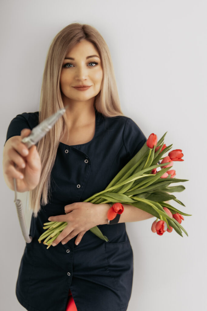 Delikatnej urody kobieta trzyma w ręce bukiet kwiatów i urządzenie