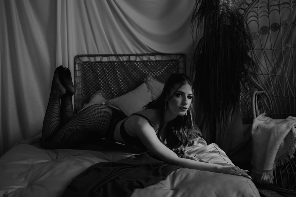 kobieta leży na łóżku w bieliźnie i czarnych rajstopach