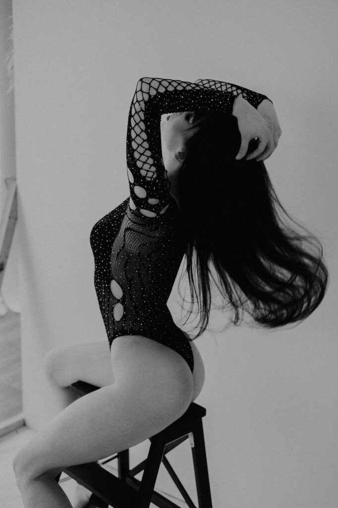 kobieta siedzi na krześle ręce ma we włosach