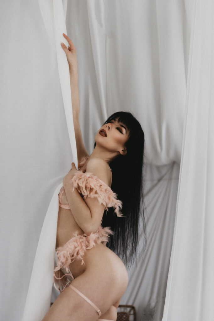 kobieta stoi przy firance w bieliźnie