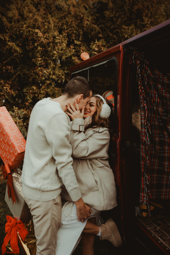 całująca się para przy samochodzie świątecznym