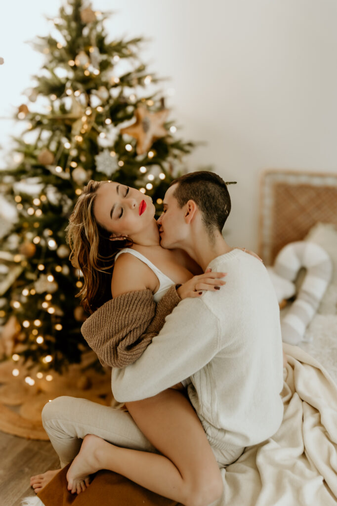 przytulająca się para zakochanych ludzi na łóżku przy choince