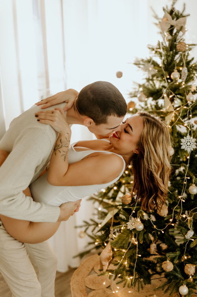 kobieta i mężczyzna całują się przy świątecznej choince
