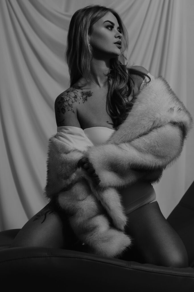 kobieta ubrana w futro siedzi na krześle