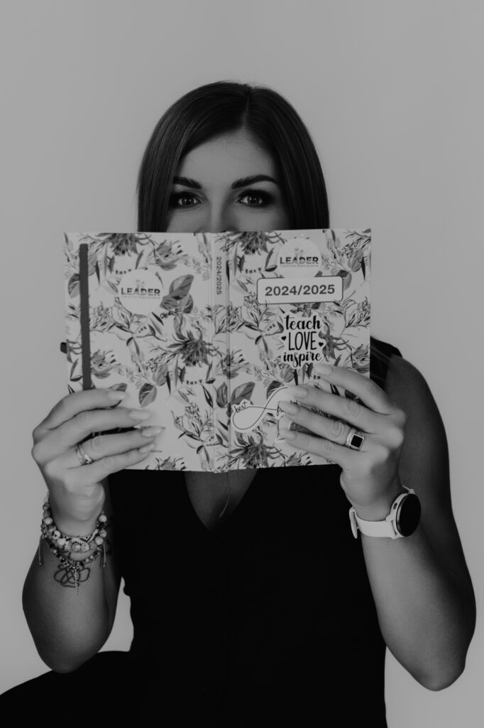 dziewczyna zeszytem zakrywa usta