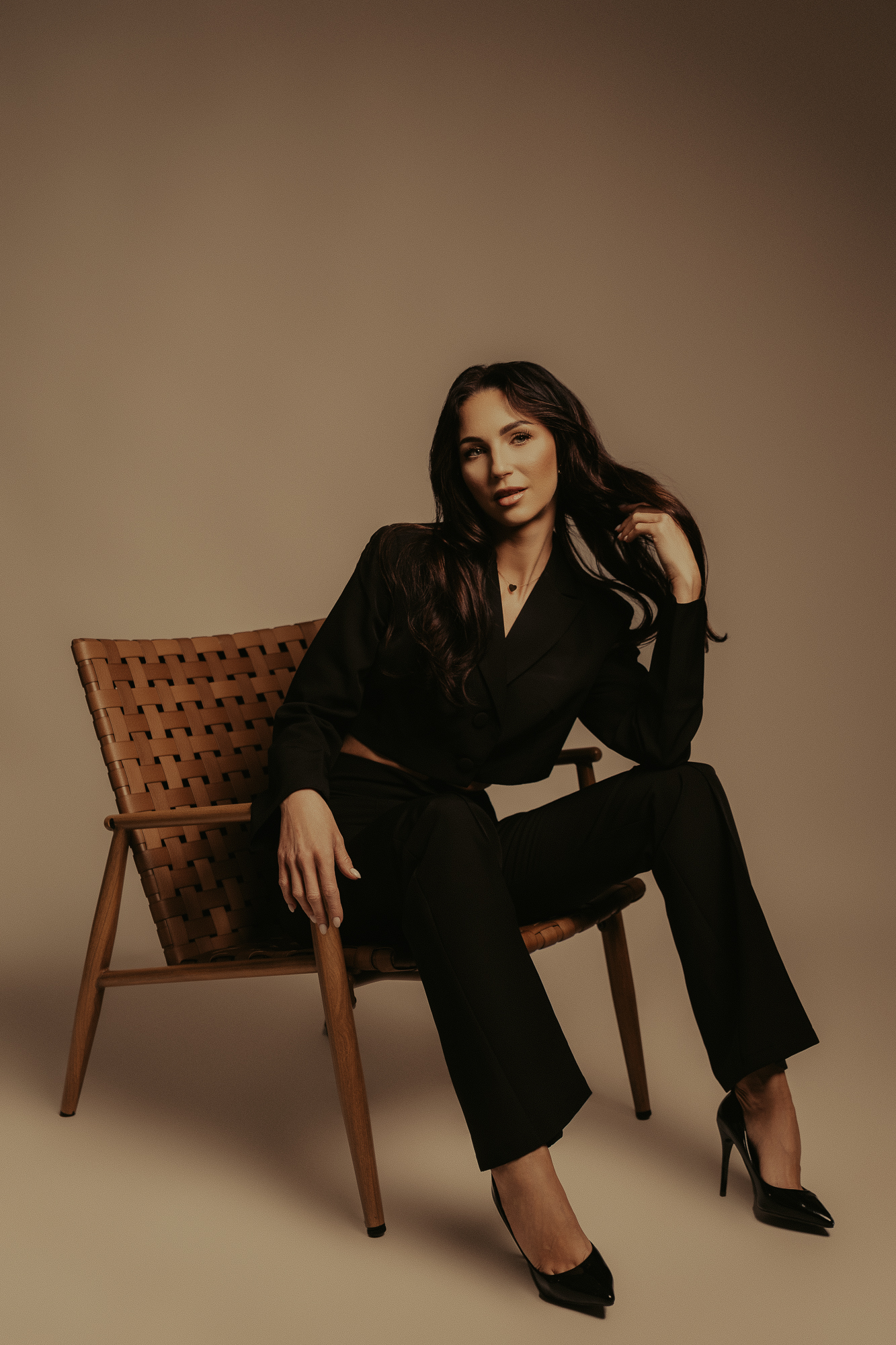 kobieta w czarnym garniturze na krześle